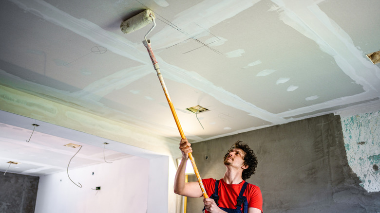 A man paints a ceiling