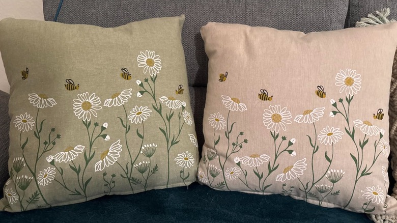 Two throw pillows with green and pink floral covers.