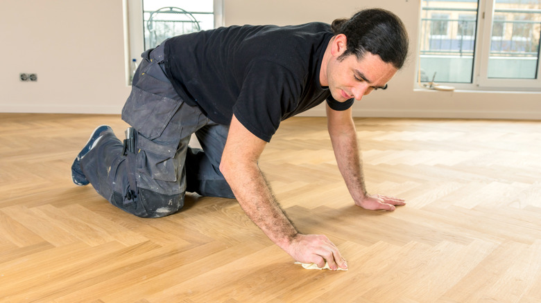 Man cleaning wood floor