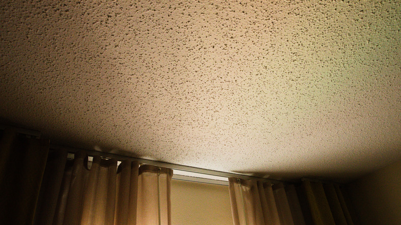 A popcorn ceiling with light from a window