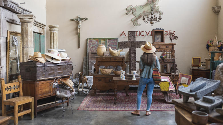 Woman looks around store for antique furniture