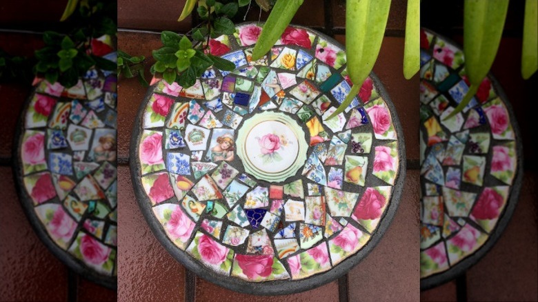 A mosaic stepping stone made with pieces of broken decorative plates