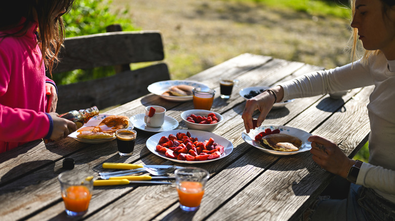 A family eating breakfast at an outdoor table