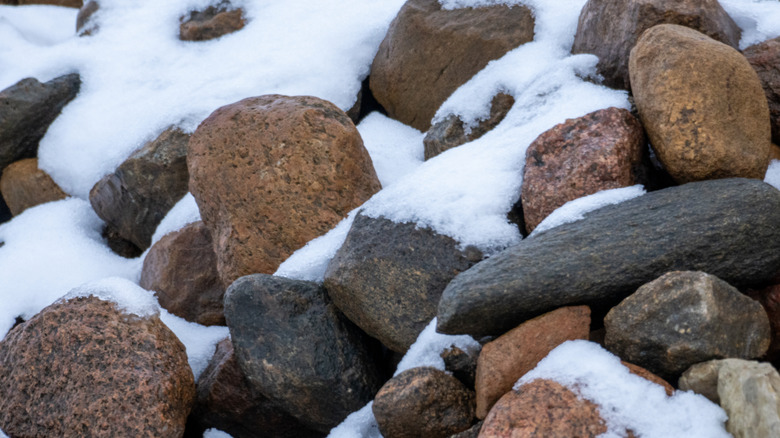 Pile of medium sized rocks covered in a layer of snow