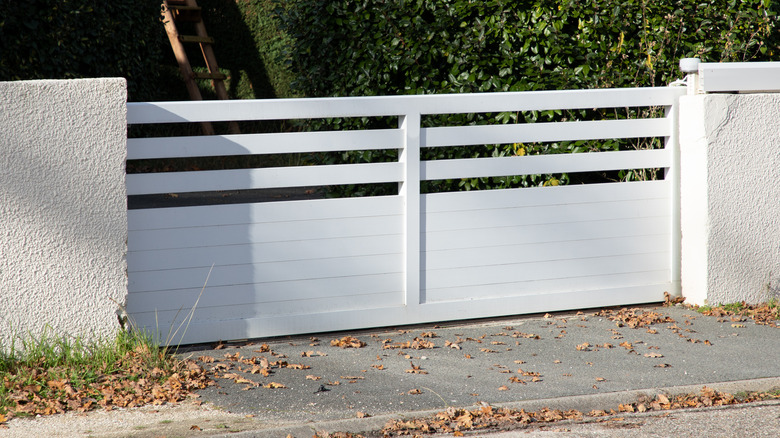 A close up on a white aluminum grille gate with horizontal rails.