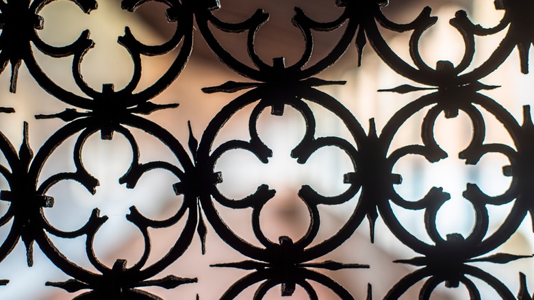 A close up on ornate, Gothic quatrefoils in a grille gate.