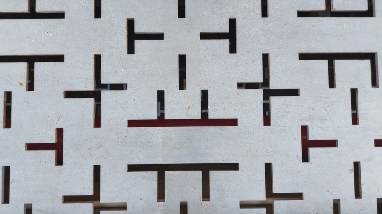 A grille grate with perpendicular lines laser engraved into a solid metal sheet.