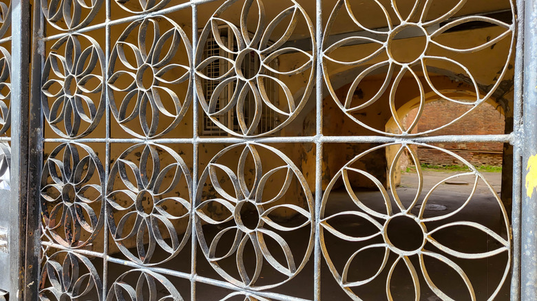 A floral wrought iron lattice pattern on a grille gate.