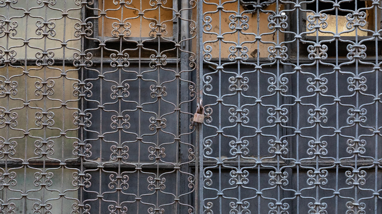 A tightly woven, scrolled double-c lattice design on a grille gate.