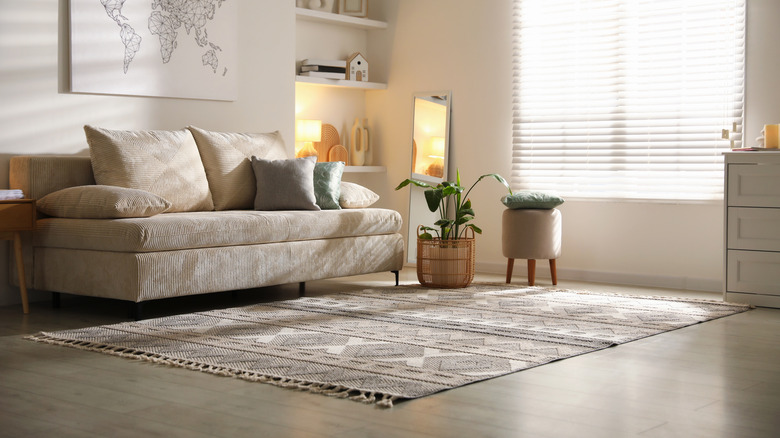 a neutral colored living space with a warm light and a rug with soft patterns and textures