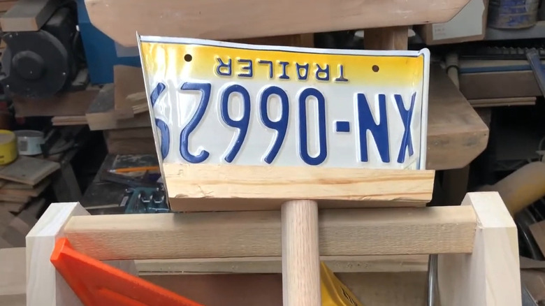 Dust pan made of license plate and a piece of wood in a workshop