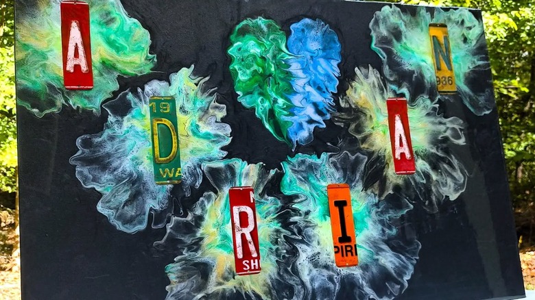 Colorful canvas art with license plate pieces spelling the name "ADRIAN"