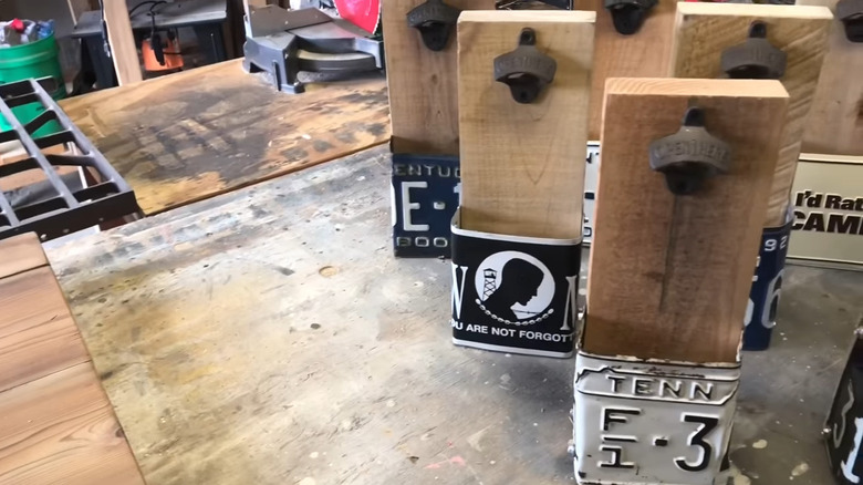 Stack of bottle openers made with license plates on a work table
