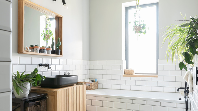 A bathroom with a large window next to a bathtub