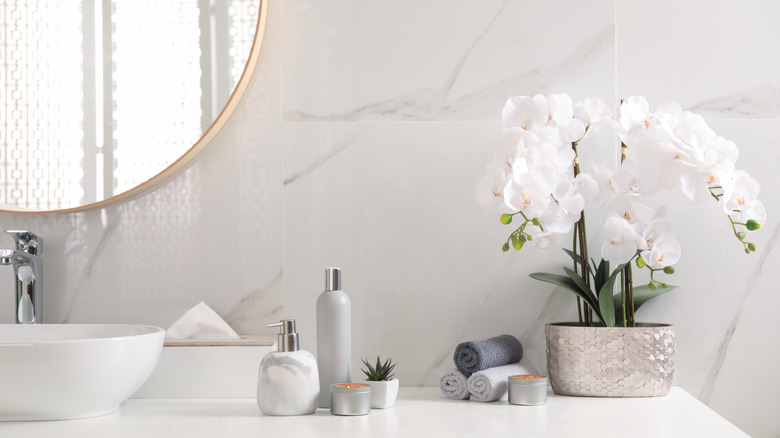 White bathroom vanity with white orchids