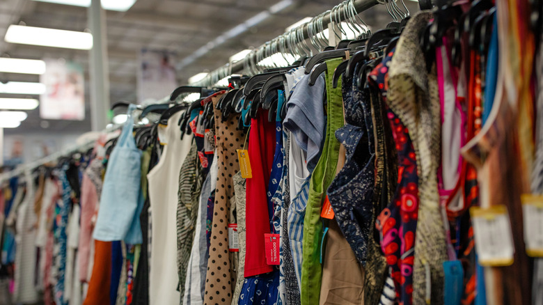 Shirts and clothes on hangers on rack at the thrift store