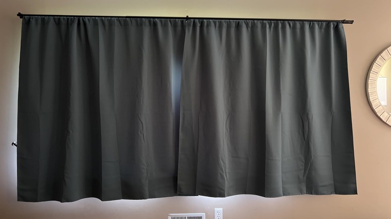 Woman opening blackout curtains