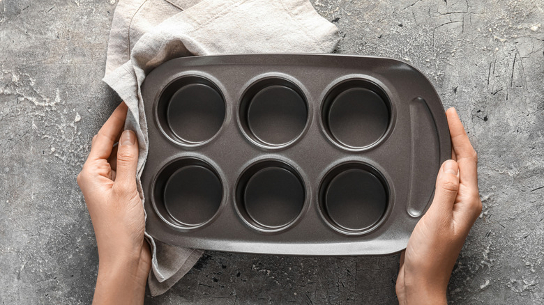 Hands holding a muffin tin