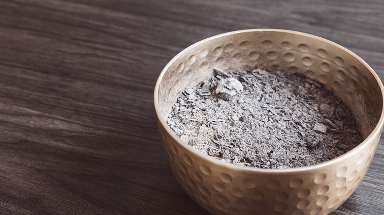 A bowl of wood ash site on a table trapping odors.