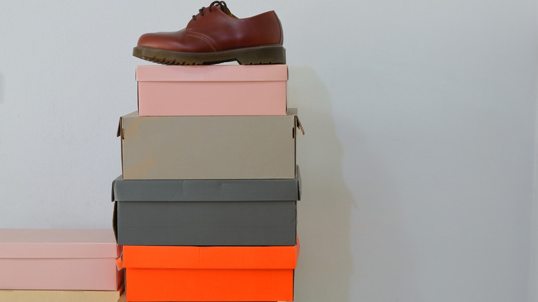 A shoe sitting on a stack of shoe boxes