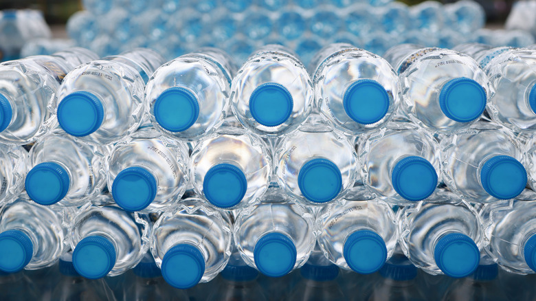Stacks of water bottles with blue caps laying down