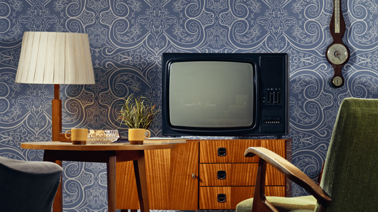 vintage tv and lamp on a console in a living room