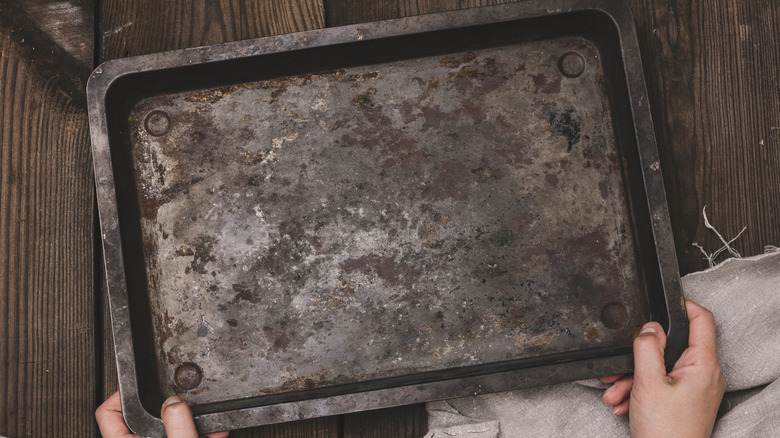 Rusty baking sheet placed on wooden surface