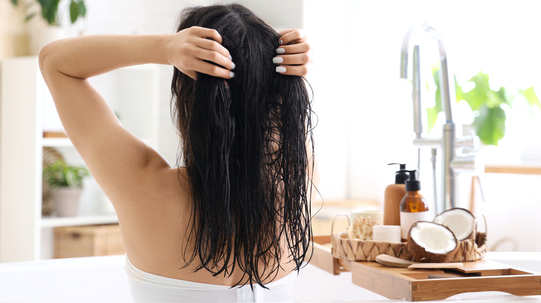 Woman applying coconut oil to hair