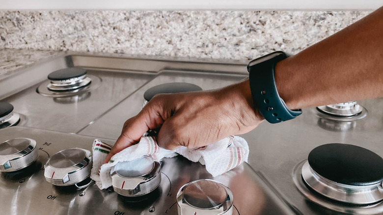 Person cleaning a stovetop