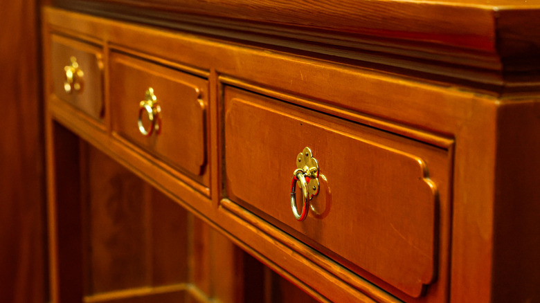 A traditional dresser with an orange wood finish.