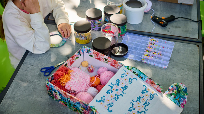 woman with decorative box containing yarn supplies
