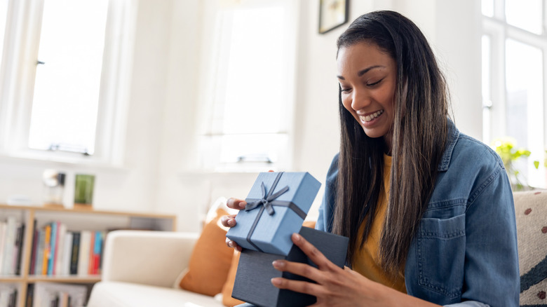 woman opening bright blue gift box