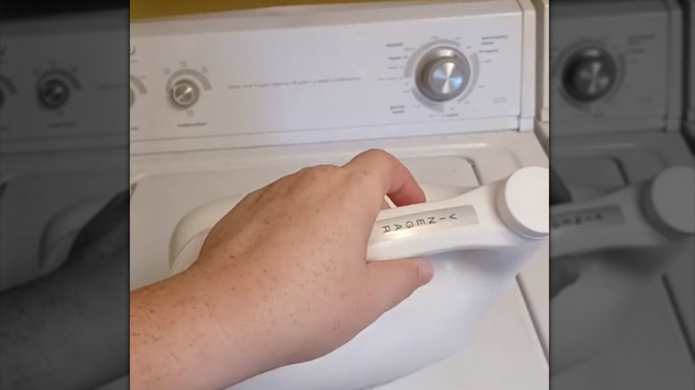 Detergent bottle with a label for vinegar over a washing machine