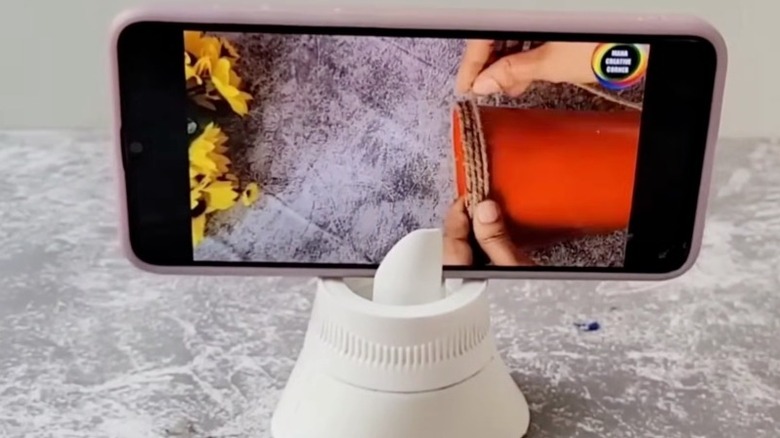 Phone in a DIY stand made from a detergent cap