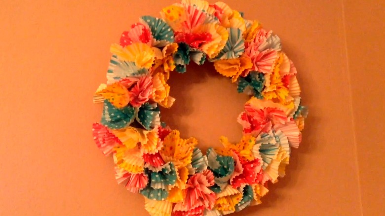 Paper wreath made from cupcake liners hung on a wall