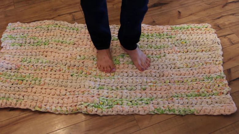 Woman standing on crocheted rag rug made from old bed sheets
