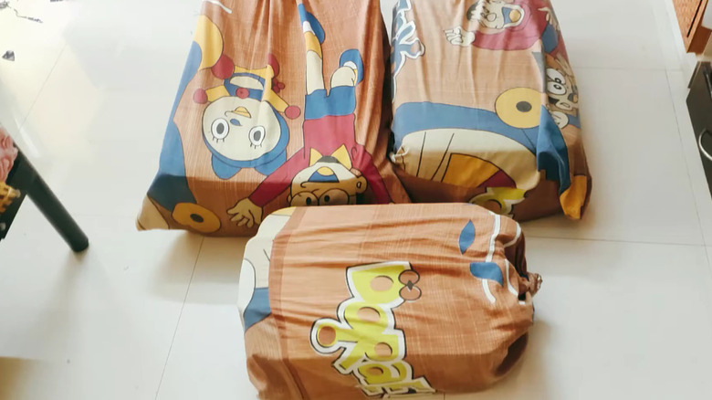 Three DIY suitcase covers made from old bed sheets