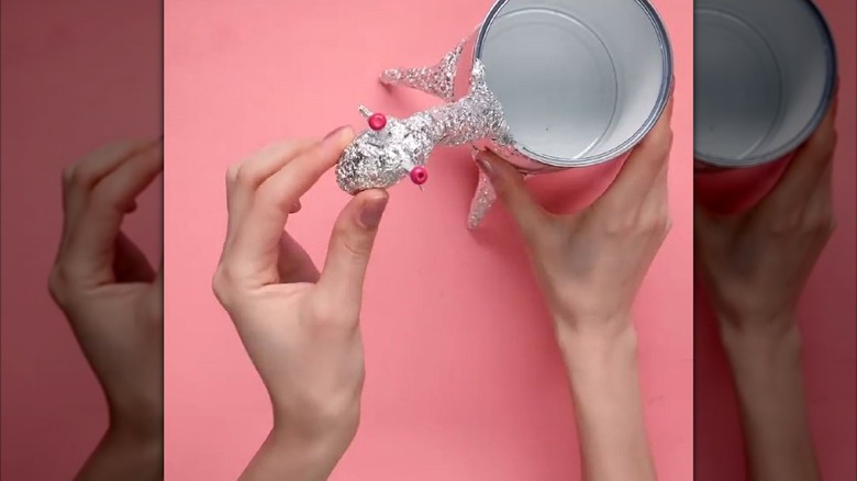 Woman creating a DIY giraffe vase out of a tin can