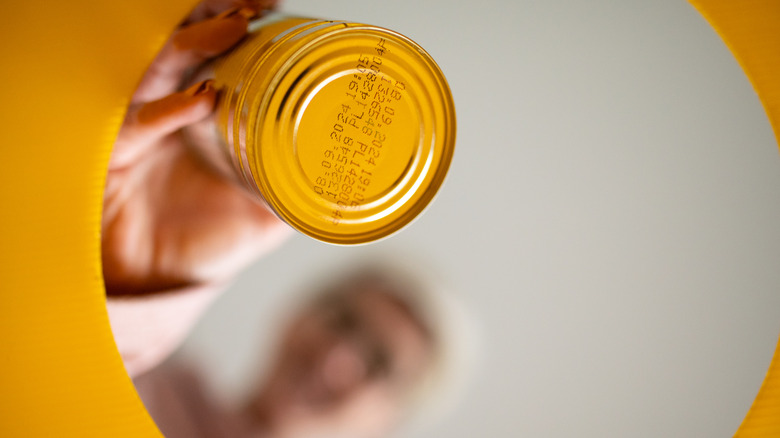 blurred image of person throwing out an empty soup can