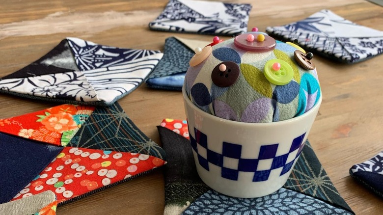 A coffee mug turned into a pincushion
