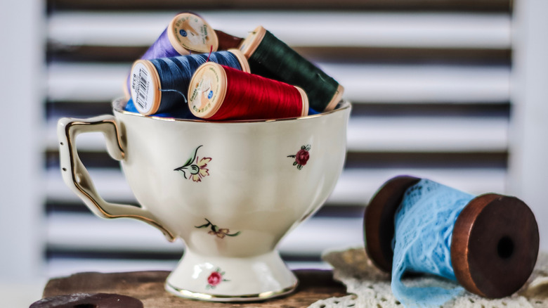 Cotton reels piled inside a mug