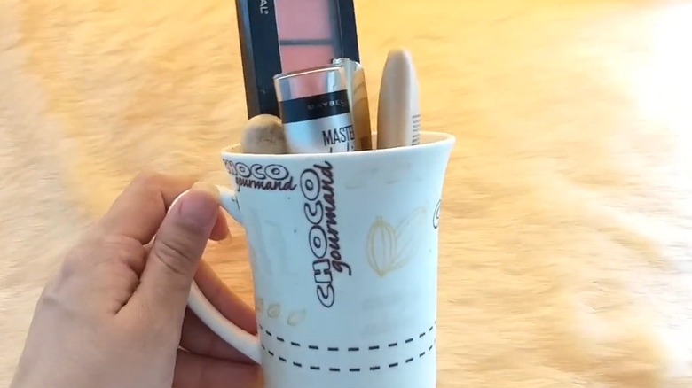Cosmetics inside a white coffee mug