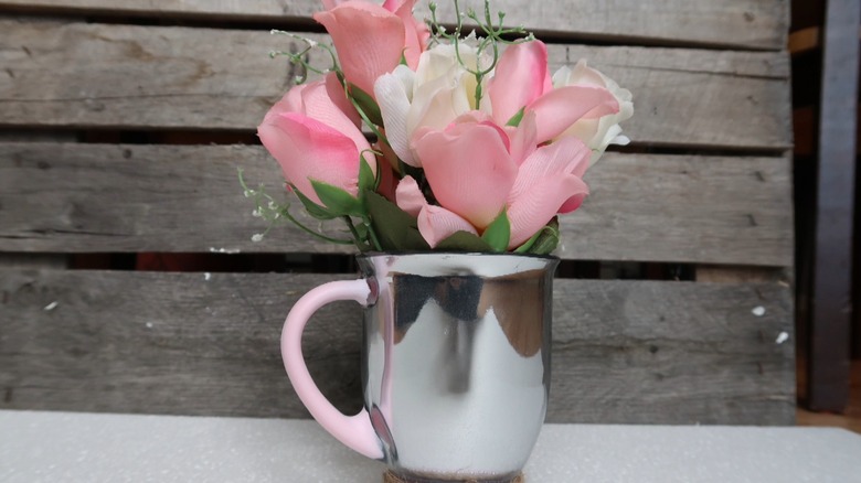 Coffee mug with cut flowers on a table