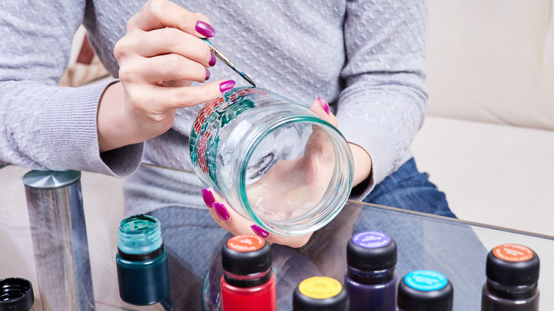 person using stained glass products to create a design on a jar