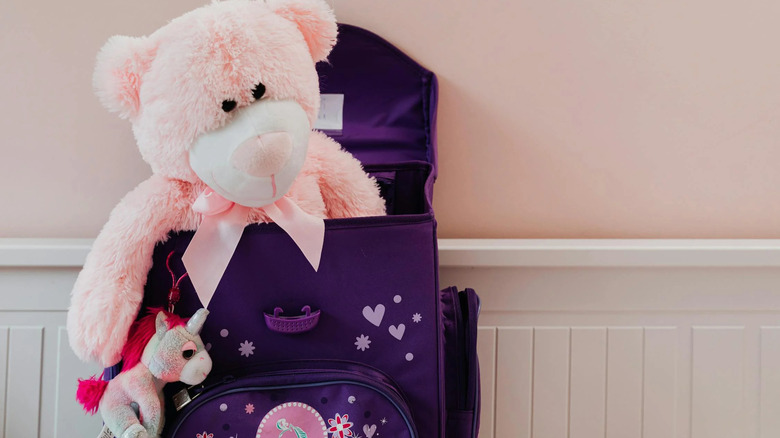 little kids backpack with teddy bear inside and unicorn keychain