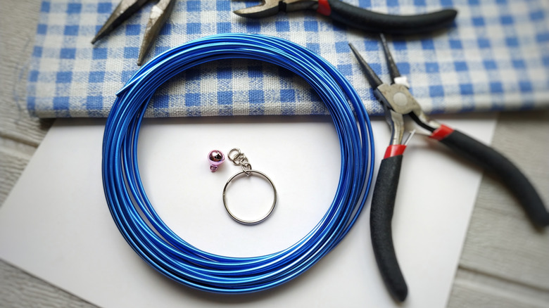taken apart keychain with blue wire and three wire cutters around it