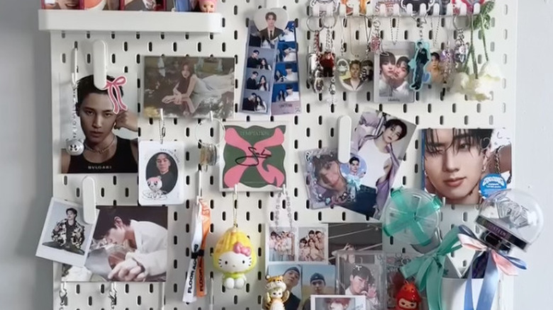 peg board wall art with photos, keychains, figurines, and ribbons