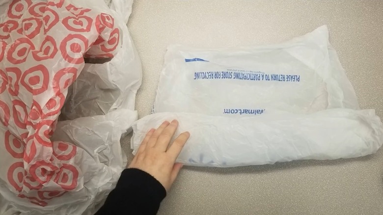 Hand rolling a white plastic bag