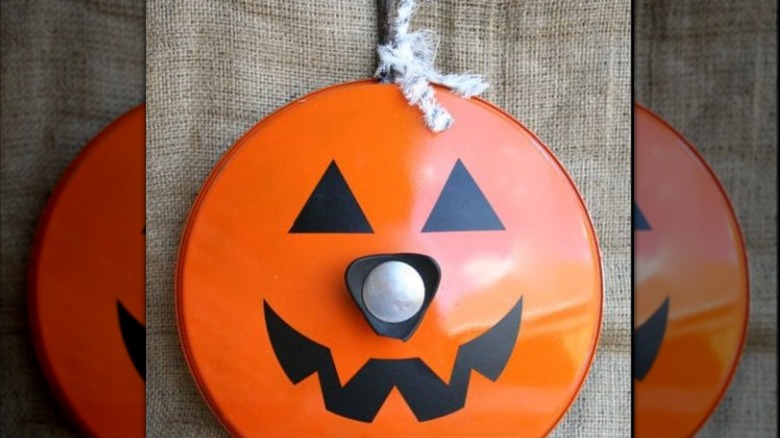 Pan lid painted as jack o' lantern.