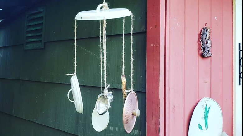 A wind chime made from multiple pot and pan lids.